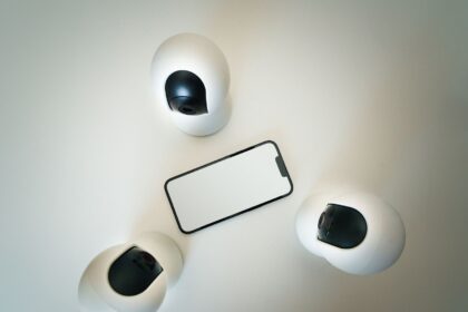 Smartphone surrounded by security cameras on a modern, minimalist setup.