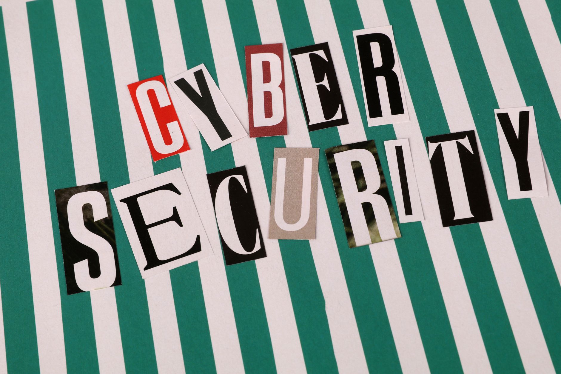 Cyber security concept depicted with a creative text collage on striped background.
