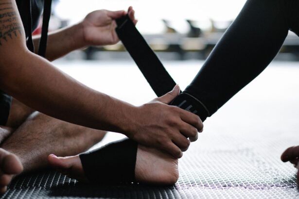 Close-up of an athlete's ankle being wrapped with an elastic bandage in a gym setting.