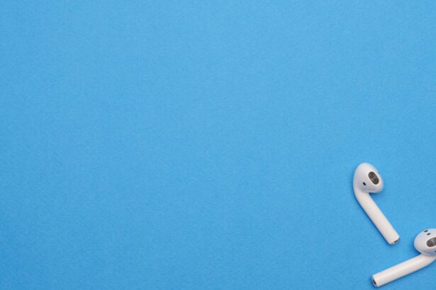 White wireless earbuds on a blue background offering ample copy space. Modern and minimalist design.