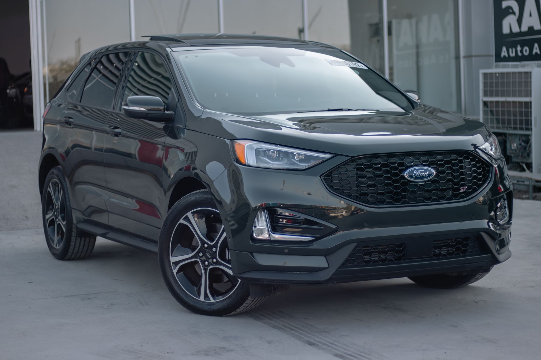 A shiny black Ford SUV parked in an auto showroom, showcasing modern design and style.