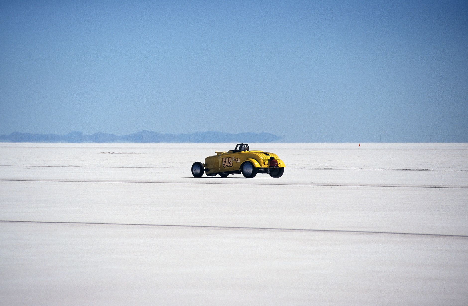 Vintage yellow hot rod racing on the Bonneville Salt Flats. High speed adventure.
