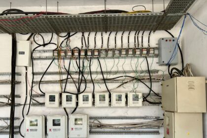 Complex network of electrical wiring and control panels in an industrial setting.