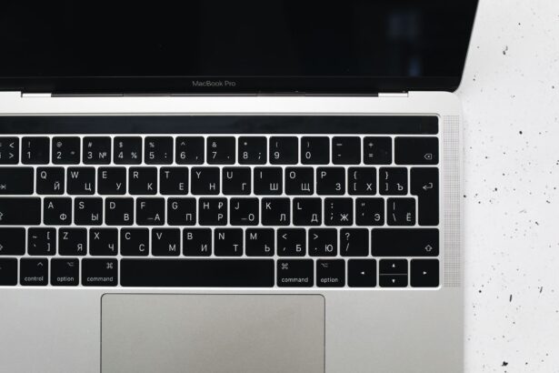 Top view of a MacBook Pro keyboard on a speckled marble surface, showcasing a Russian Cyrillic layout.