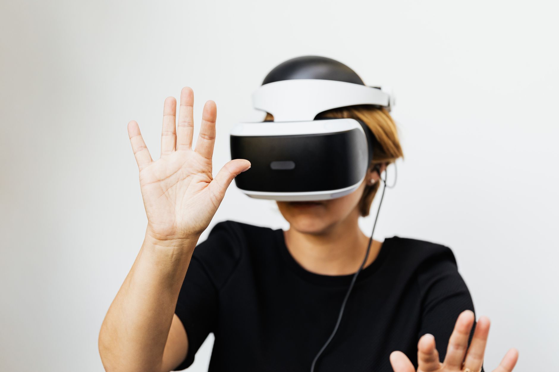 Woman experiencing virtual reality with VR headset on white background.