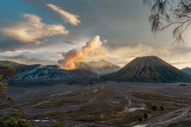 A breathtaking view of Mount Bromo in East Java, Indonesia, with erupting smoke at sunrise.