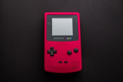 Close-up of a red Nintendo Game Boy Color on a dark backdrop, showcasing retro gaming nostalgia.