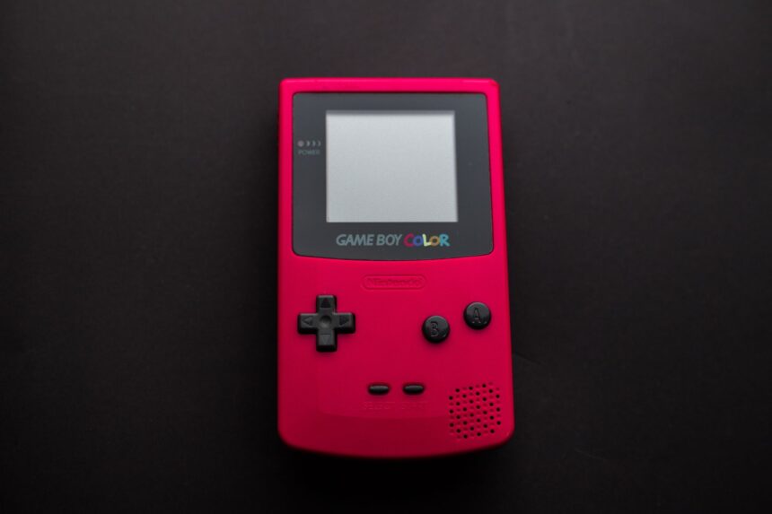 Close-up of a red Nintendo Game Boy Color on a dark backdrop, showcasing retro gaming nostalgia.