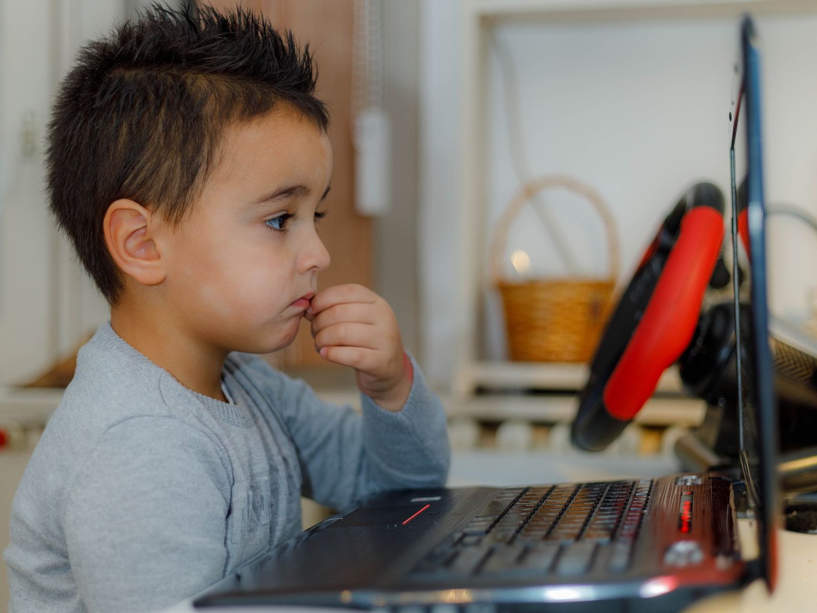 A young child focused on a laptop for educational purposes at home.