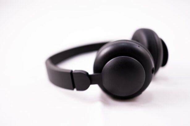 Closeup of contemporary shiny black wireless headphones placed on white surface in light studio in daylight