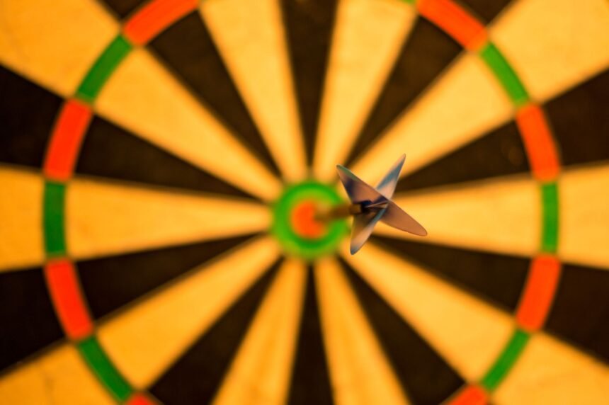 A close-up of a dart perfectly hitting the bullseye on a dartboard, symbolizing accuracy.