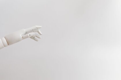 Minimalist image of a robotic hand reaching out on a white background.