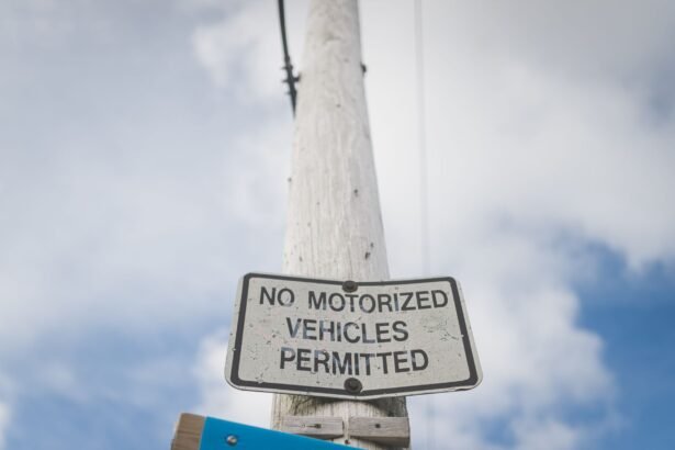 A street sign prohibiting motorized vehicles, mounted on a post against a blue sky.