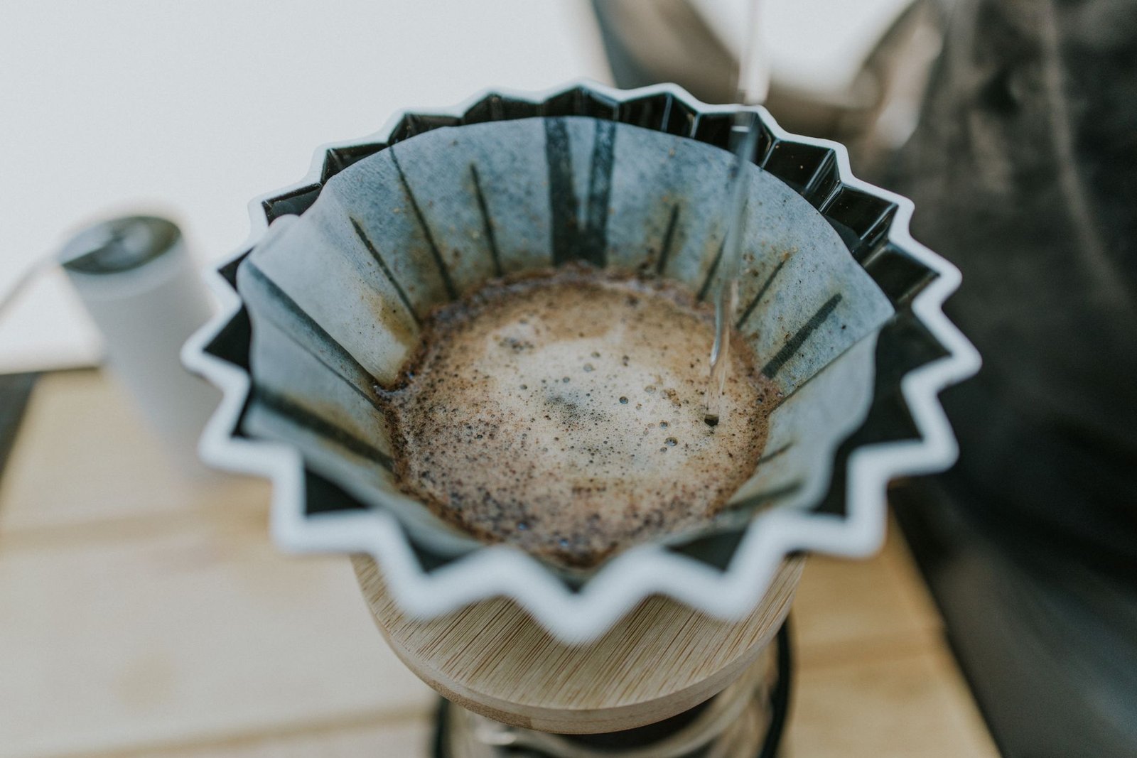 Close-up of a pour-over coffee brewing process with a ceramic dripper.