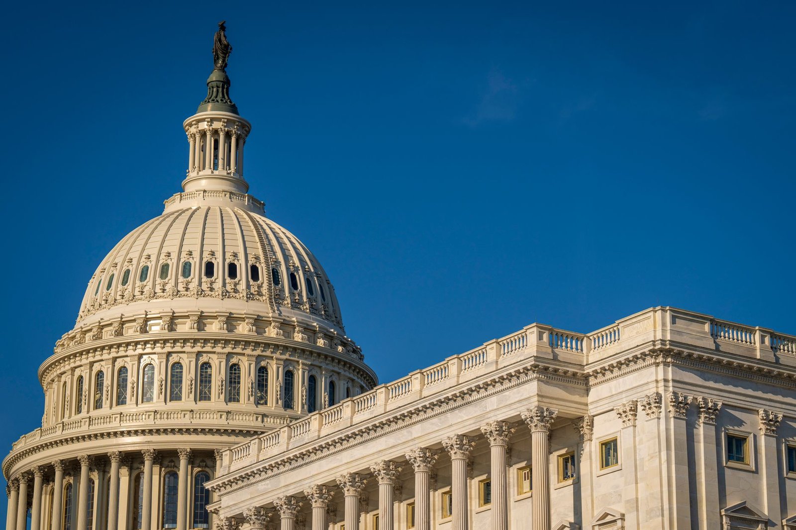 The iconic dome of the United States Capitol against a clear blue sky, showcasing its classical architecture.