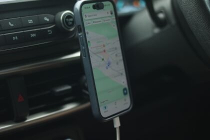 A smartphone with a map app displayed inside a car, showing modern navigation.