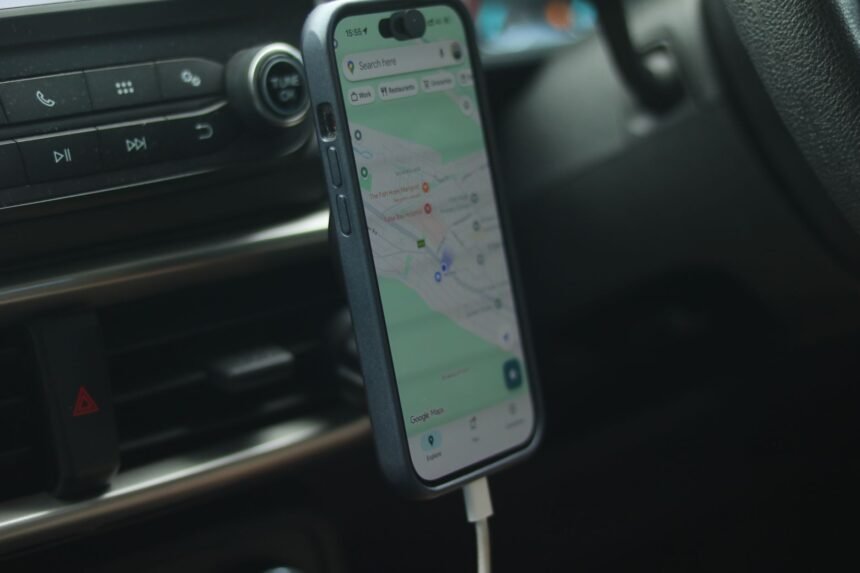 A smartphone with a map app displayed inside a car, showing modern navigation.
