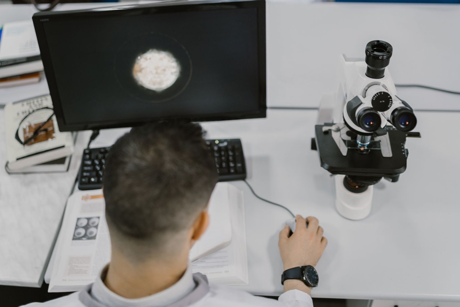 Scientist working with a microscope in a modern laboratory setup.