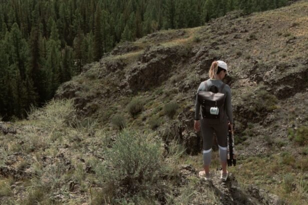 A lone female hiker explores a scenic mountainous trail surrounded by lush pine forest.