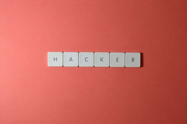 Close-up of the word 'HACKER' made with letter tiles on a red background, emphasizing cybersecurity.