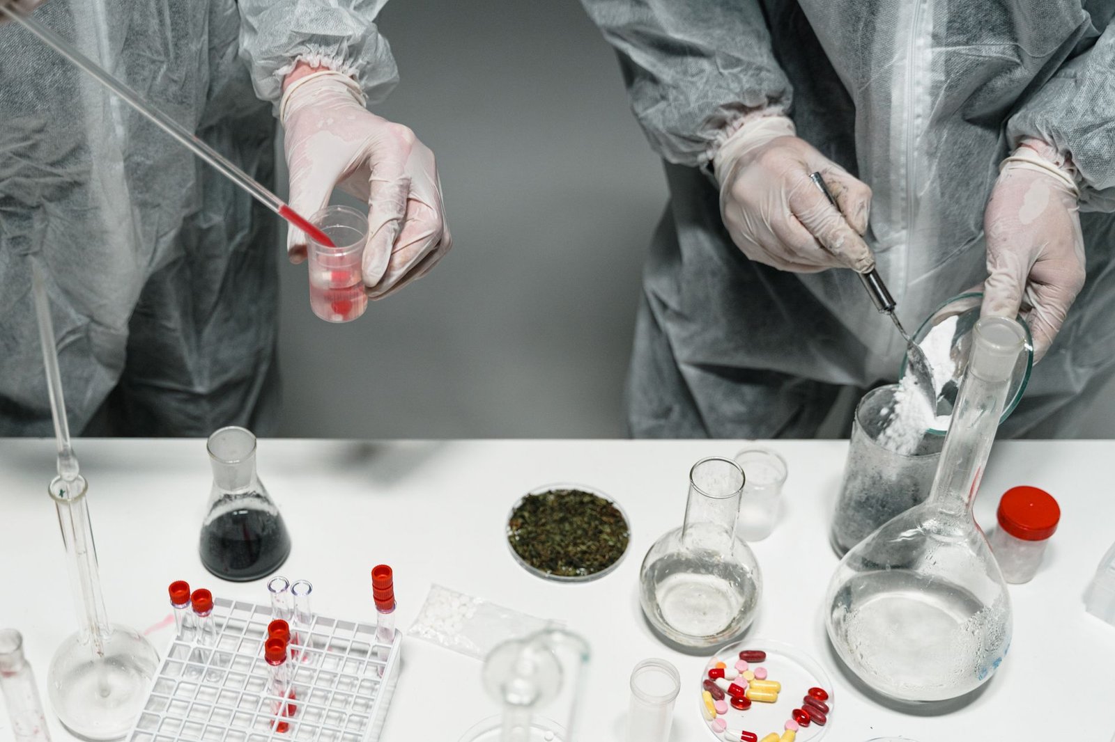 Scientists in protective gear conducting experiments in a modern laboratory setting.