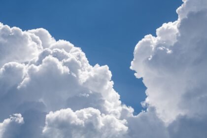 Beautiful cumulus clouds fill the summer sky, creating a serene and peaceful atmosphere.