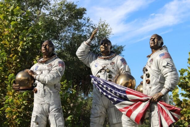 Bronze statue of Apollo astronauts at Cape Canaveral, holding a flag.