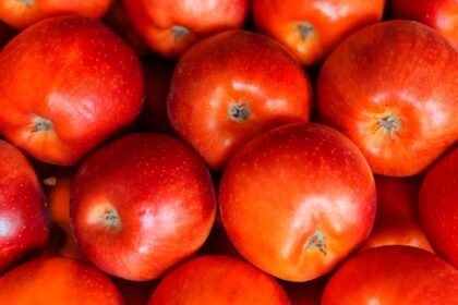 Vibrant red apples stacked together, showcasing fresh and juicy appeal.