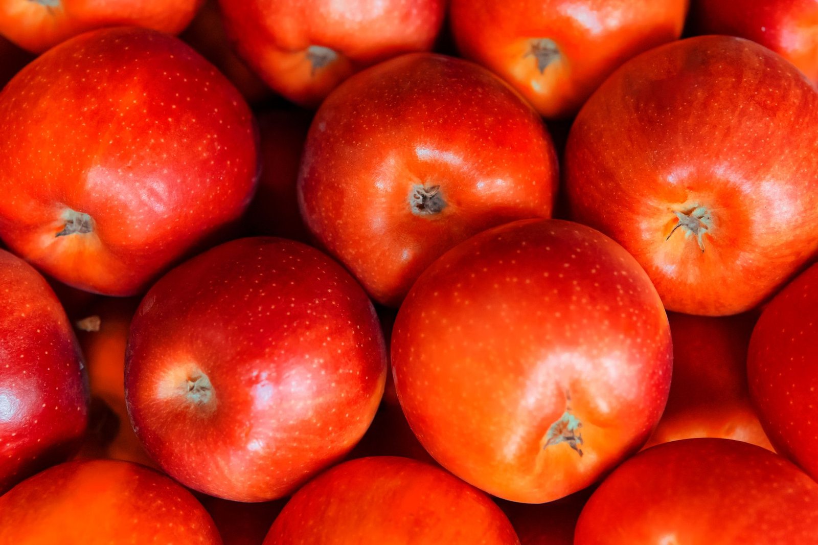 Vibrant red apples stacked together, showcasing fresh and juicy appeal.