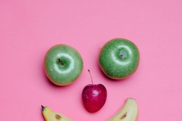 Top view of fresh ripe banana and green and red apples arranged as smile on pink background