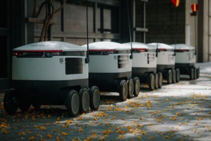 Futuristic delivery robots lined up outdoors, showcasing innovative modern technology.