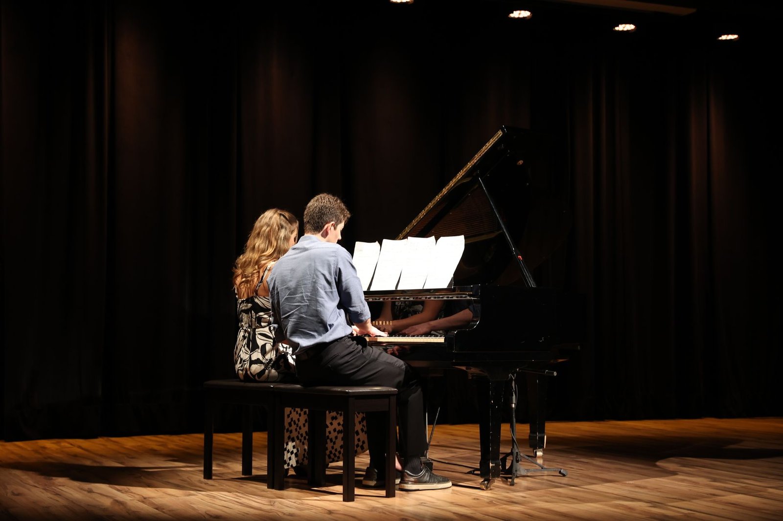 A captivating piano duet performance by a man and woman on stage in Uberlândia, Brasil.
