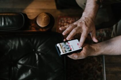 Overhead view of a man using a smartphone app while seated in a stylish room.
