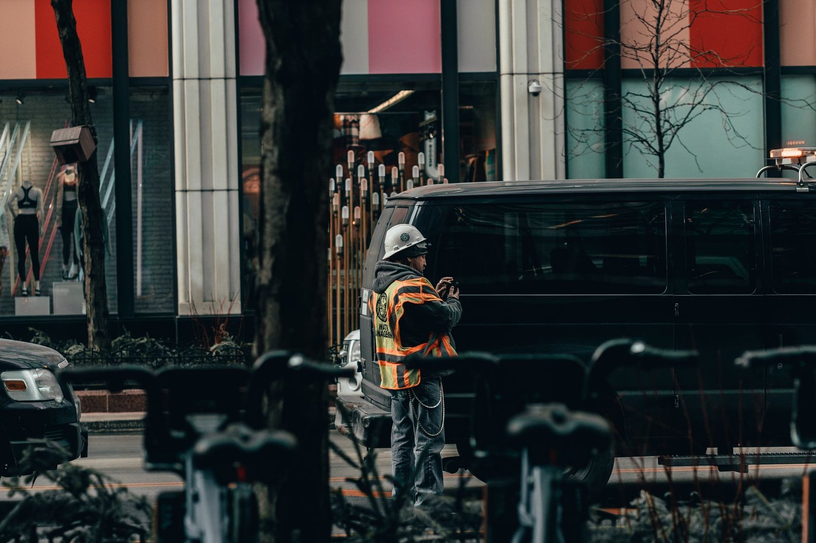A safety worker in a reflective vest manages traffic on a busy Chicago street.