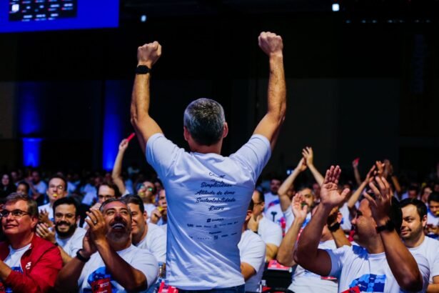 Excited spectators cheer for the speaker at a lively conference in Campinas, Brazil.