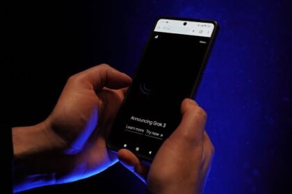 Close-up of hands holding a smartphone displaying 'Announcing Grok 3' on a dark background.