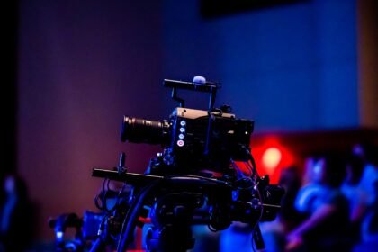 A high-quality camera setup capturing a live studio event with an audience in the background.