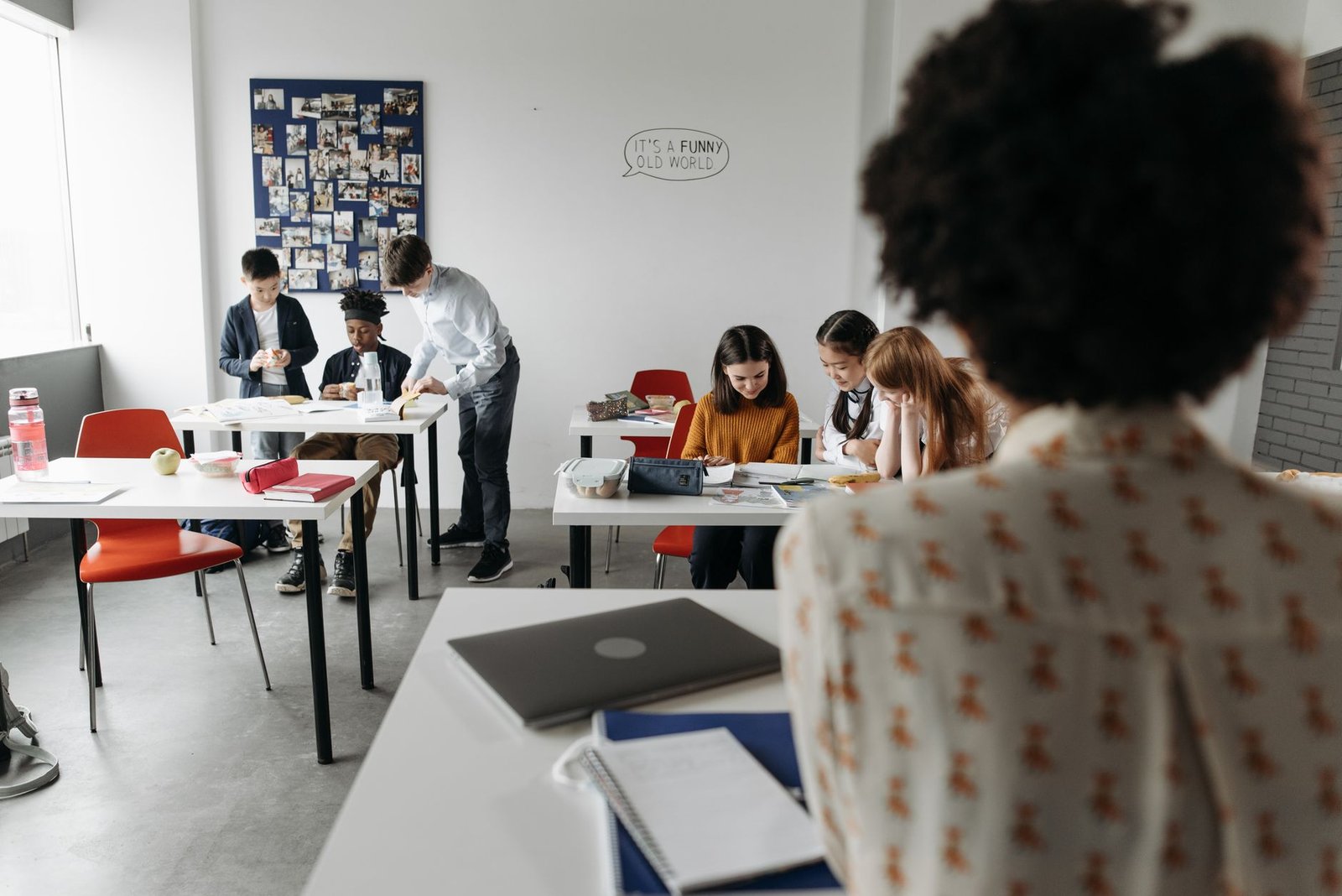Students focused in a modern classroom with diverse activities and interactions.