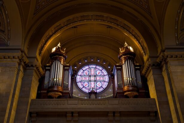 Ornate pipe organ and stained glass window inside a grand church interior, showcasing architectural elegance.