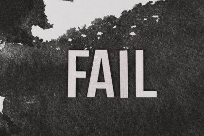 Grayscale image of the word 'FAIL' on a textured, monochrome background.
