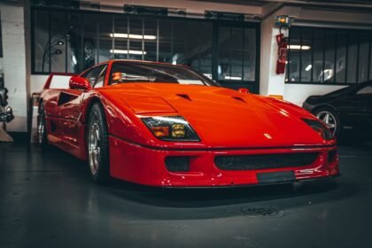 Red sports car exhibited in a Paris garage, capturing its classic sleek design.