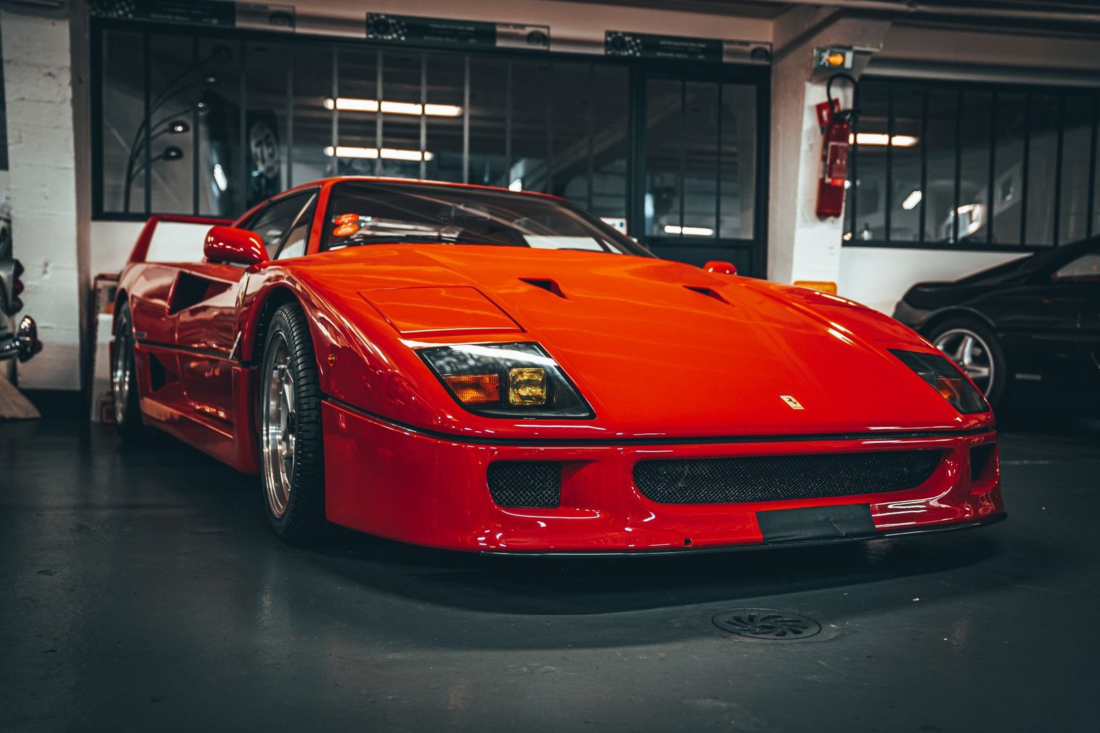 Red sports car exhibited in a Paris garage, capturing its classic sleek design.