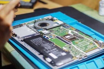 Close-up of laptop being repaired with visible components and tools.