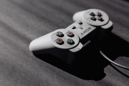 Retro Sony game controller with classic buttons on a textured dark surface, showcasing vintage electronics.