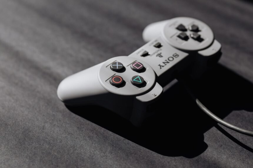 Retro Sony game controller with classic buttons on a textured dark surface, showcasing vintage electronics.