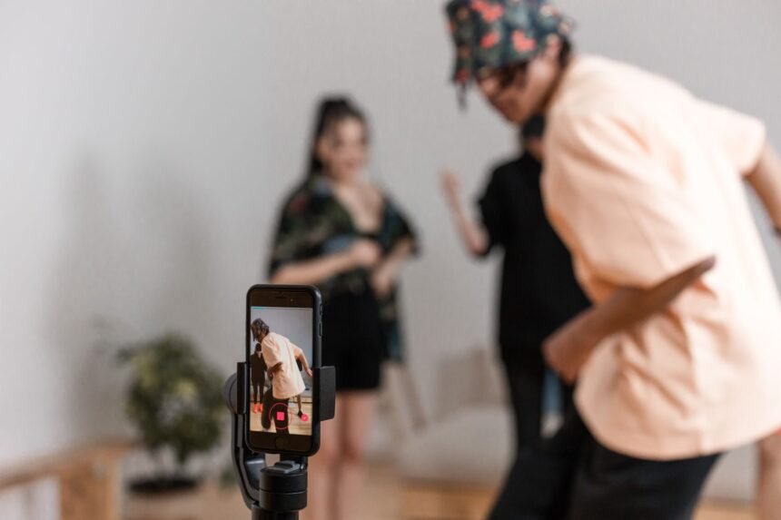Vibrant indoor scene of people dancing recorded on a smartphone for a social media platform.