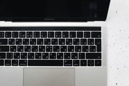 Top view of a MacBook Pro keyboard on a speckled marble surface, showcasing a Russian Cyrillic layout.