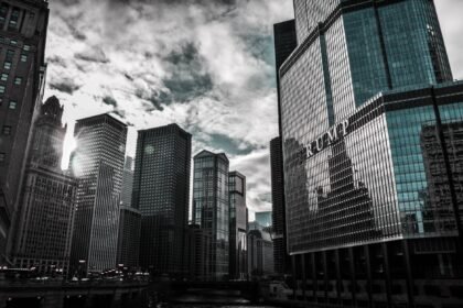 Chicago cityscape featuring Trump Tower with dramatic reflections against a cloudy sky.