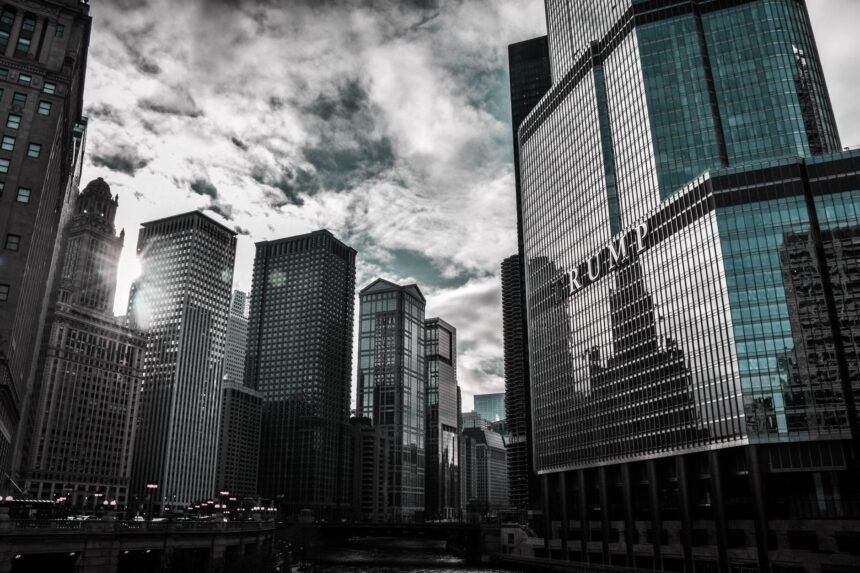 Chicago cityscape featuring Trump Tower with dramatic reflections against a cloudy sky.