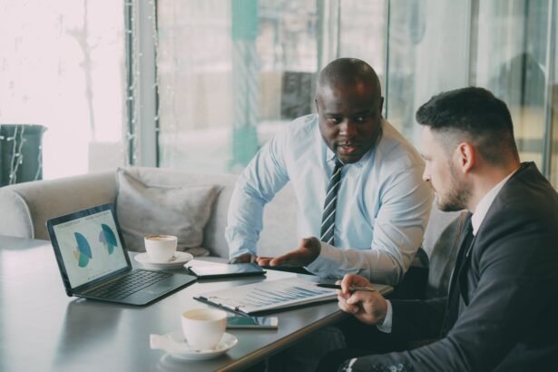 Two businessmen discussing data at a cafe while enjoying coffee.